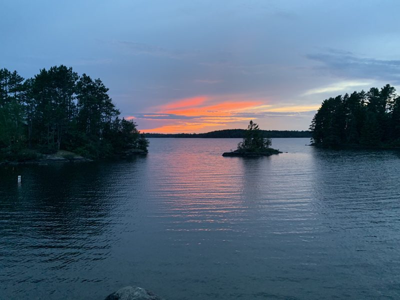 Sunset over a lake with a small pine island near Ely, Minnesota