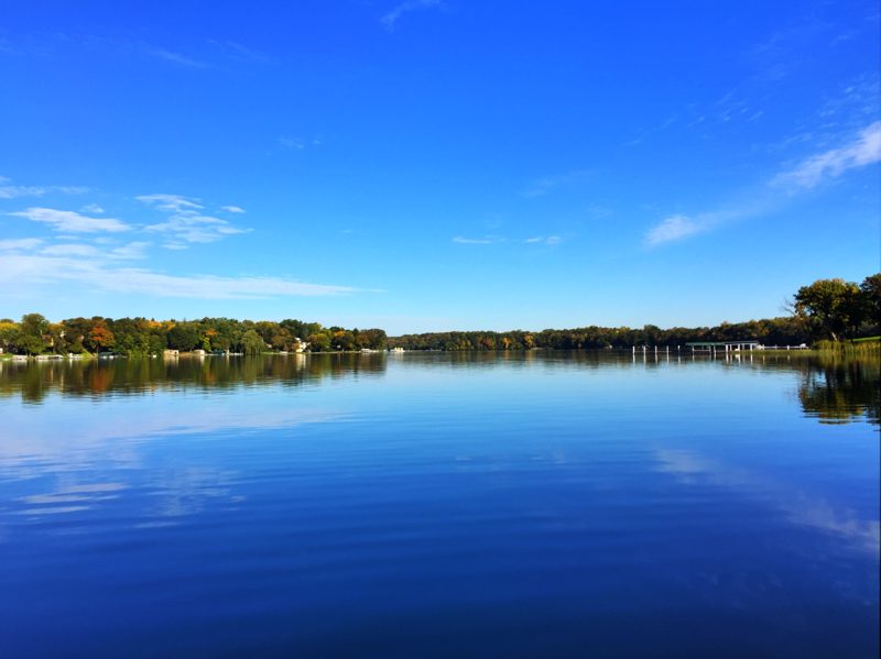 Calm blue lake reflecting a treeline on Lake Minnetonka